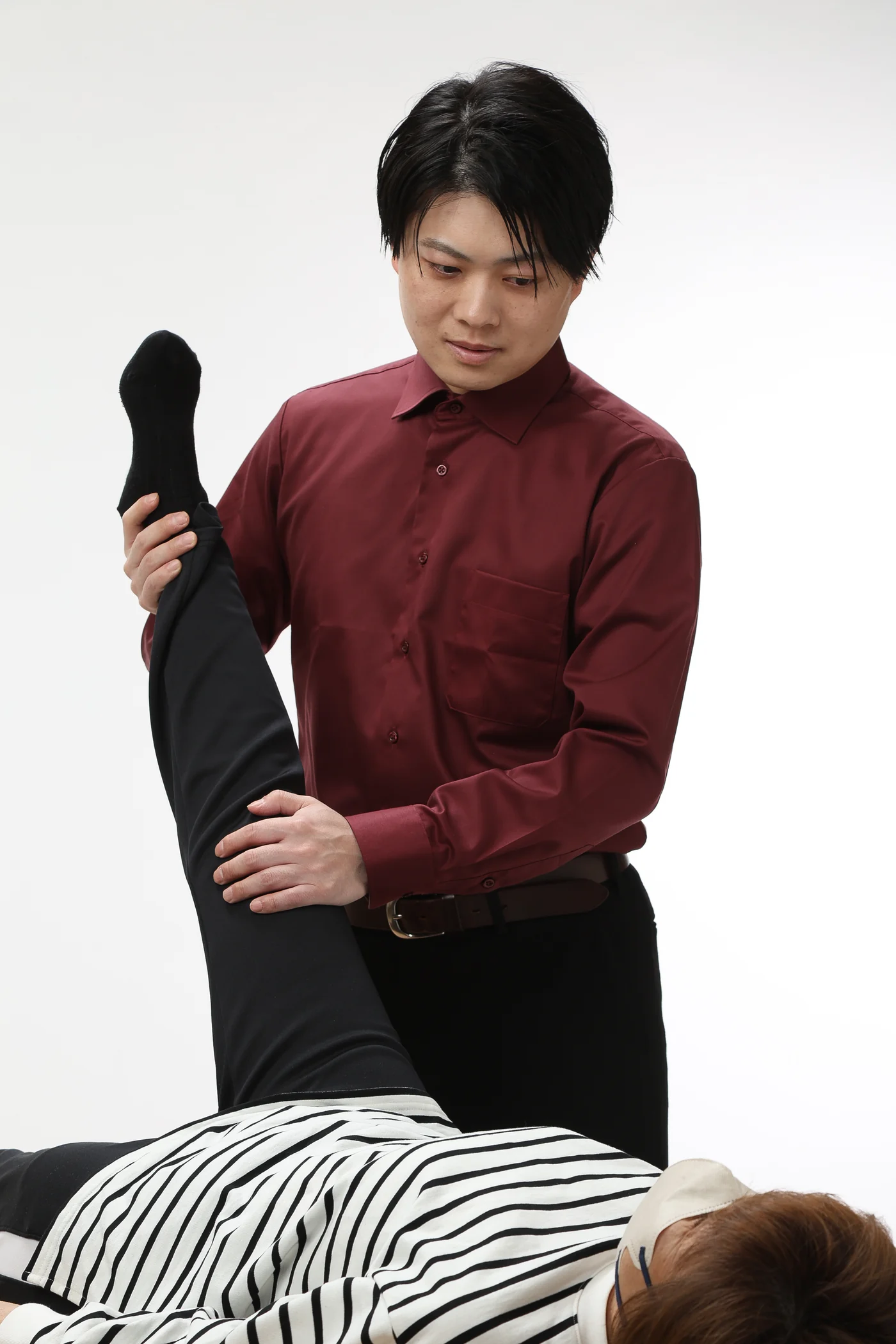 中村優太が患者さまの脚の動きを検査している様子