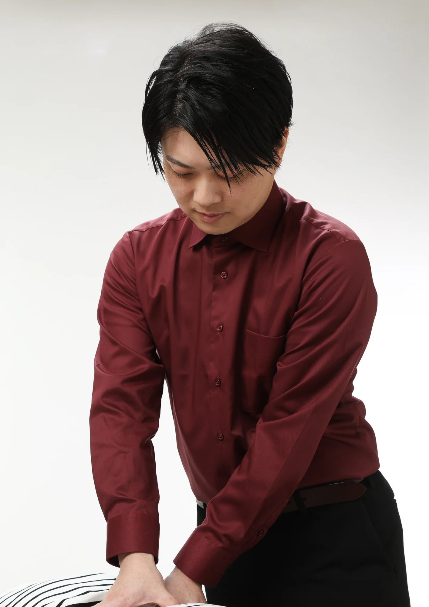 鍼灸院Aquaの中村優太が患者さまの身体に手を当てて施術している様子
