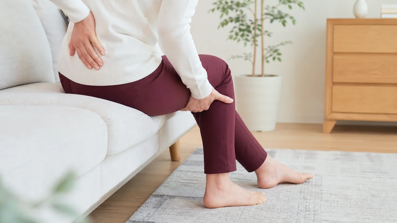 座位で腰と大腿後面へ手を添える様子